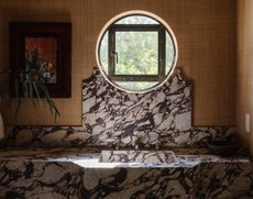 A powder room with glasscloth wall covering and marble sink