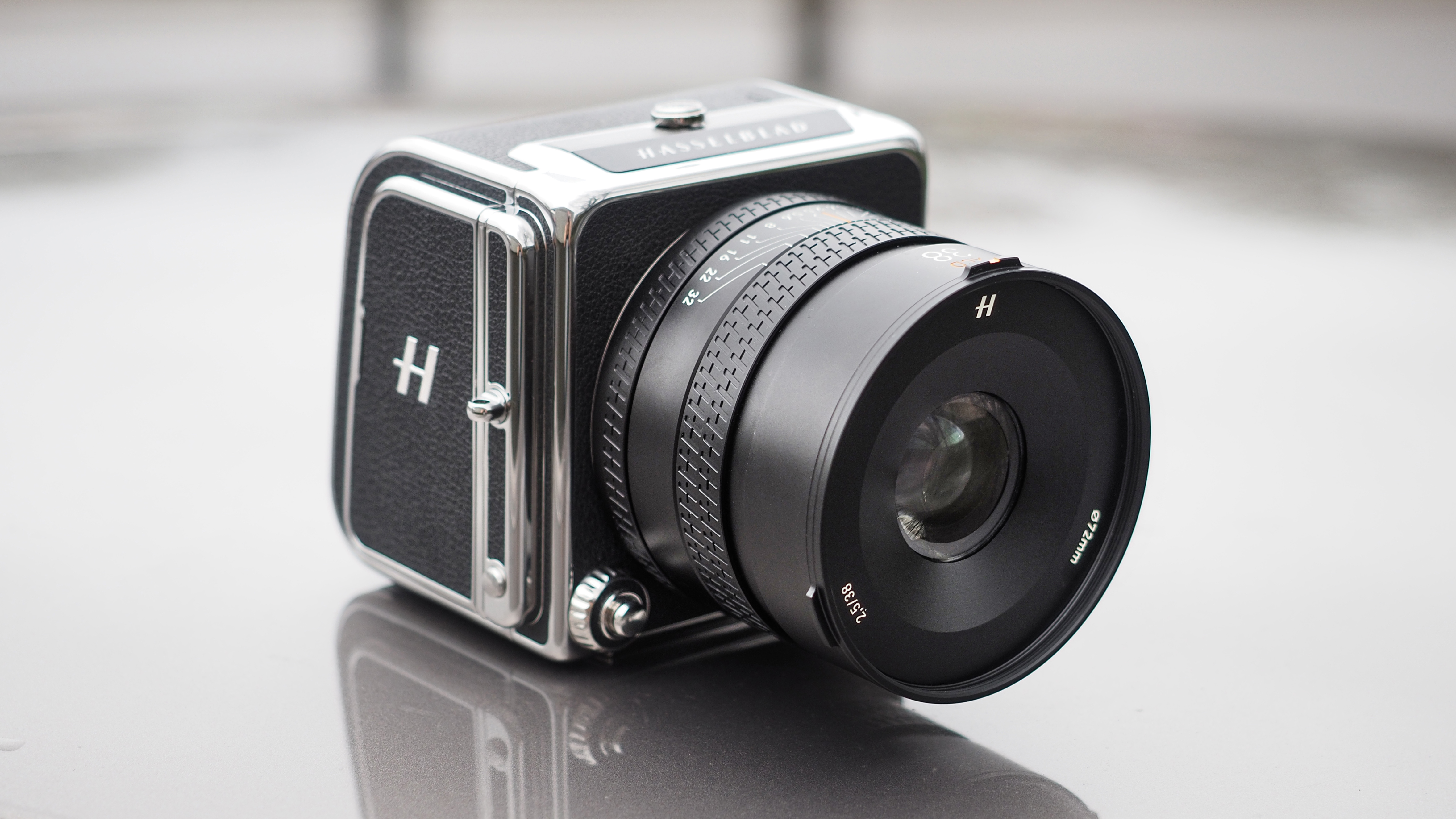 The Hasselblad 907X &amp;amp; CFV 100C medium format camera with digital back, on a wooden table with artistic lighting