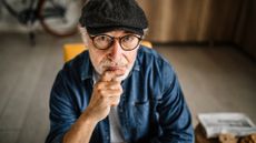 handsome white bearded senior man with cap and glasses