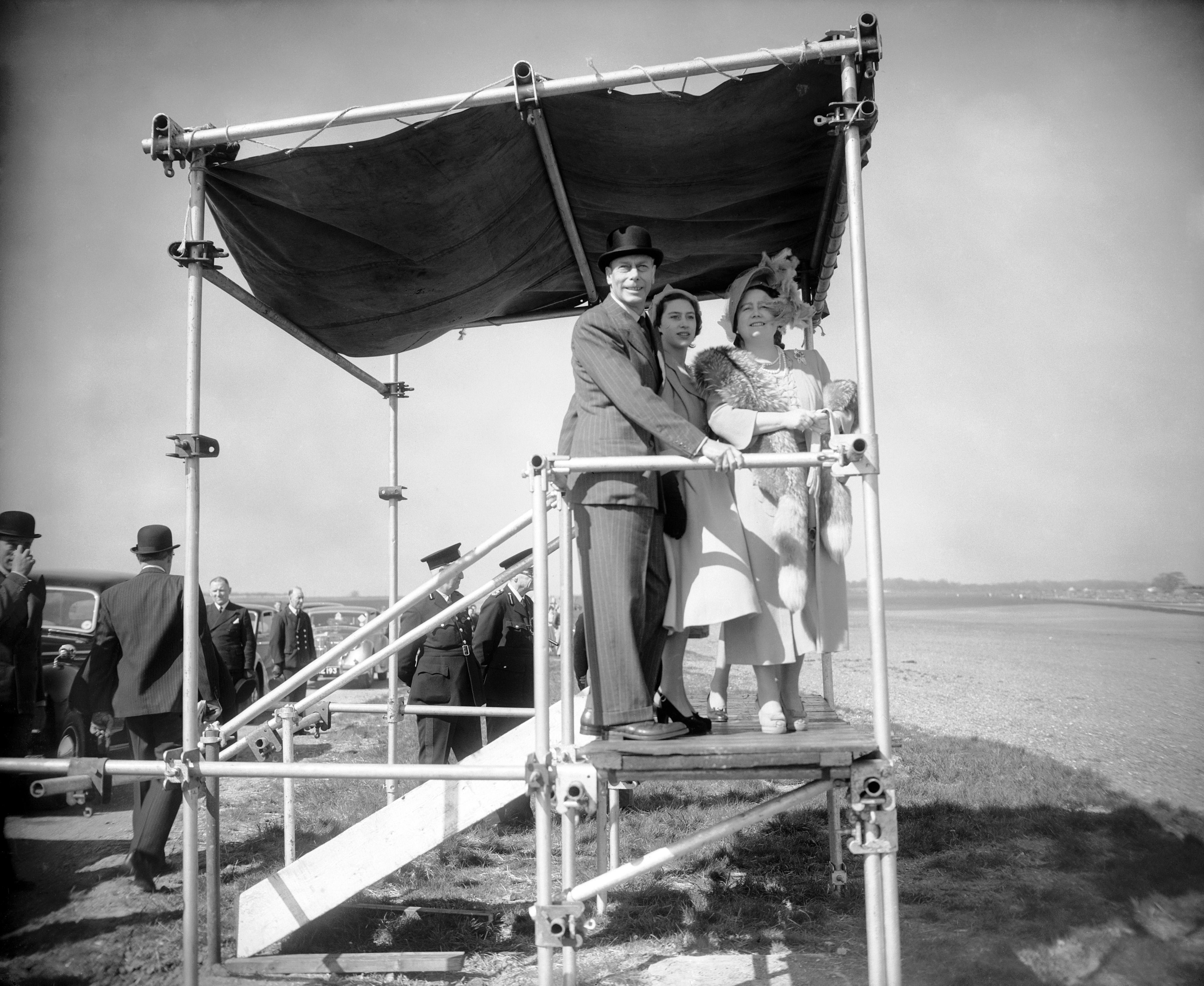 King George, Princess Margaret and Queen Elizabeth stand on a makeshift platform to watch the the 1950 British Grand Prix