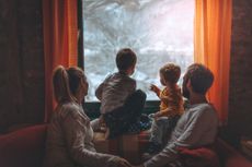 family looking out of a window in the cold