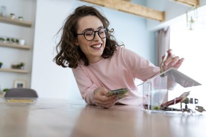 Woman putting money into a Perspex box