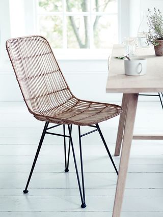 stylish dining chair with a strong black iron frame and woven rattan in tonal shades of blonde.