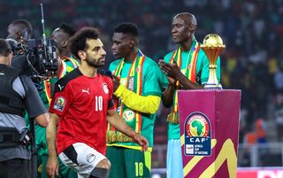 Mohamed Salah walks past the AFCON trophy on the way to collect his runners-up medal