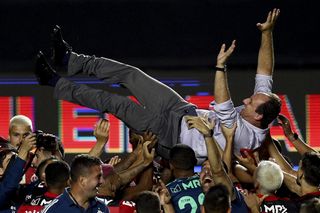 Flamengo coach Rogerio Ceni is thrown into the air by his players after winning the Brazilian title in 2021.