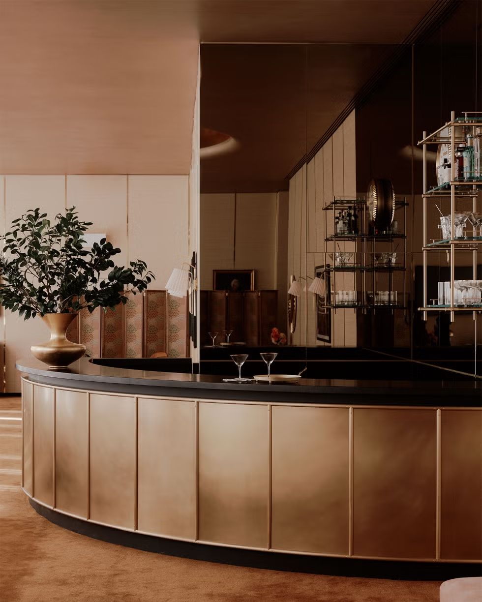 A 1970s-inspired bar lounge features stunning gold-hued finishes.