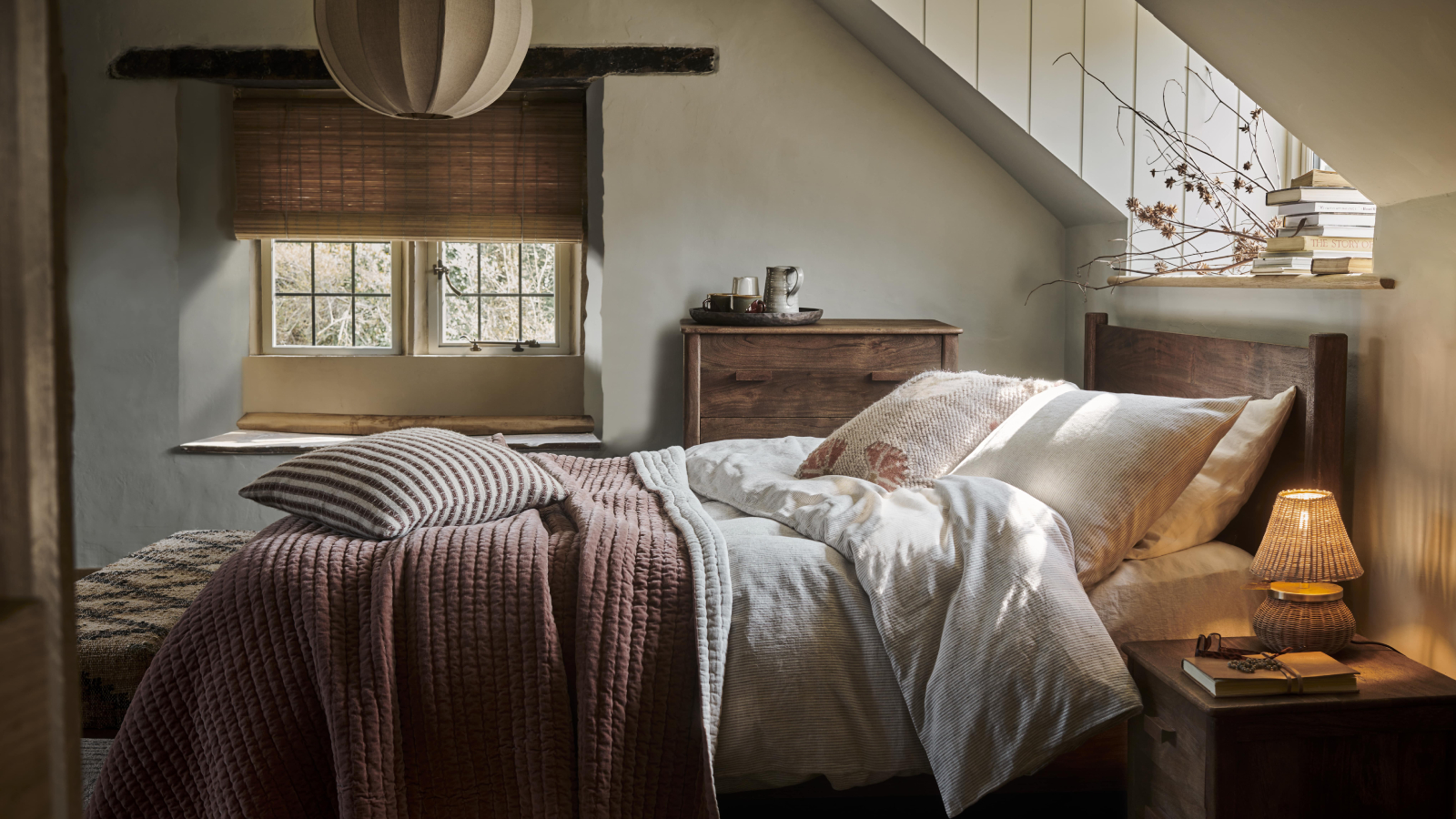 small bedroom with two windows, one over the bed, cream pendant light and small beside light on beside table