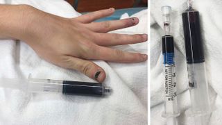 Woman's blue hand and vials of drawn blood