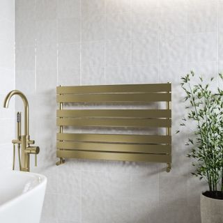 brass horizontal wall mounted towel radiator on white wall