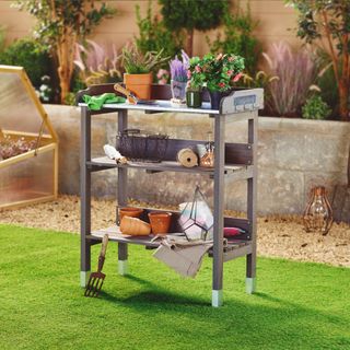 Aldi potting bench filled with various gardening items