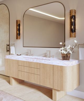 Wood and marble bathroom with gold hardware inlaid with pink onyx