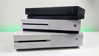 Xbox One, Xbox One S, and Xbox One X stacked on top of each other. 