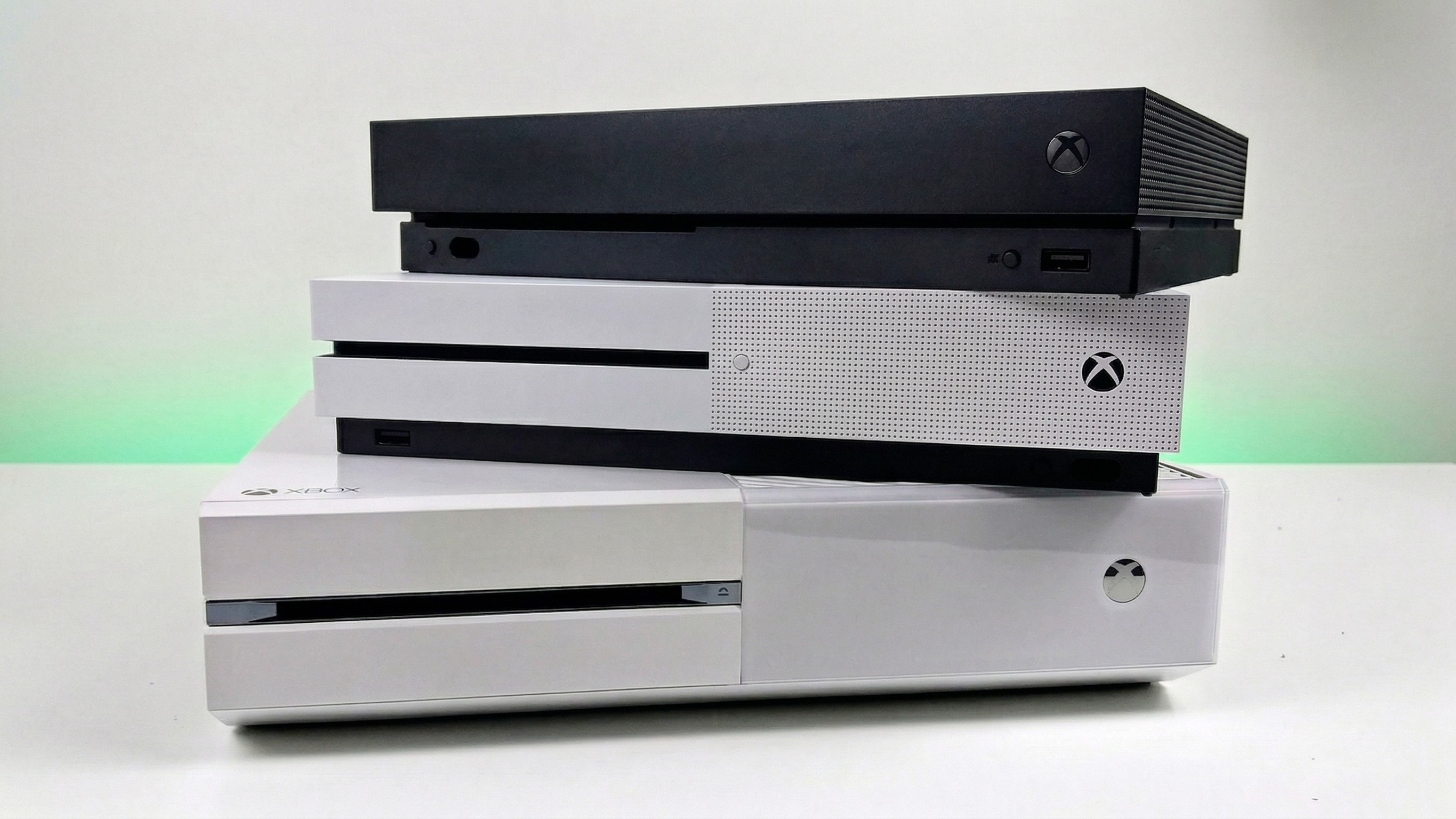 Xbox One, Xbox One S, and Xbox One X stacked on top of each other. 