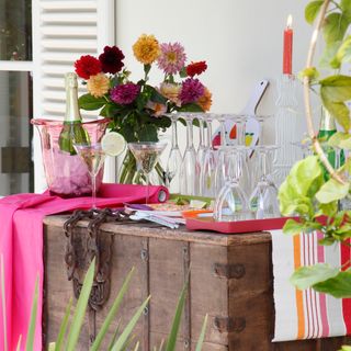 garden party drinks station with storage trunk and pink linen