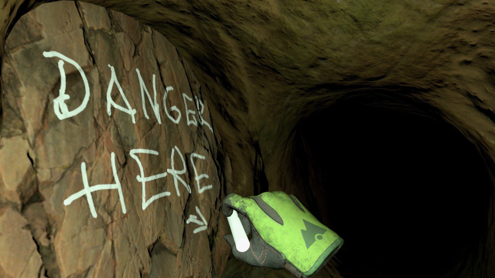 Cave Crave screenshot showing a gloved hand writing on a cave wall with white chalk "danger here"