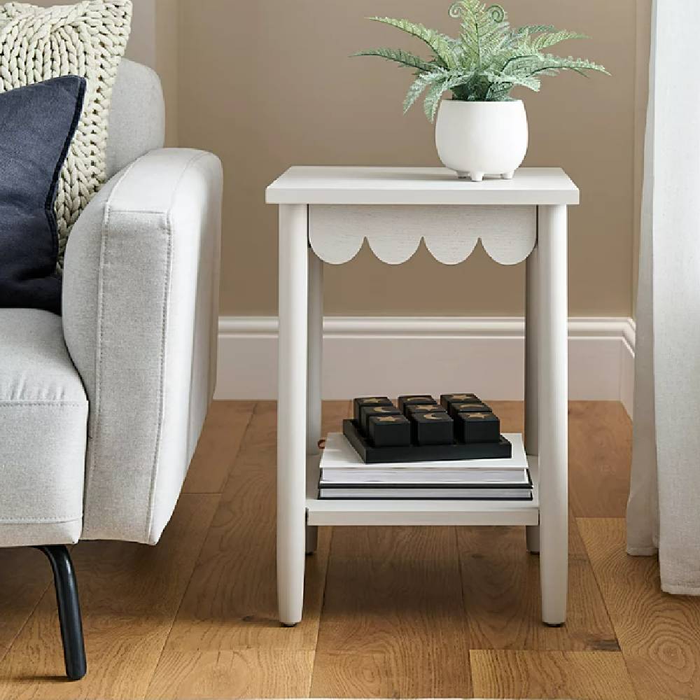 A modern, white, scalloped side table from George at ASDA, next to a modern, cream sofa.