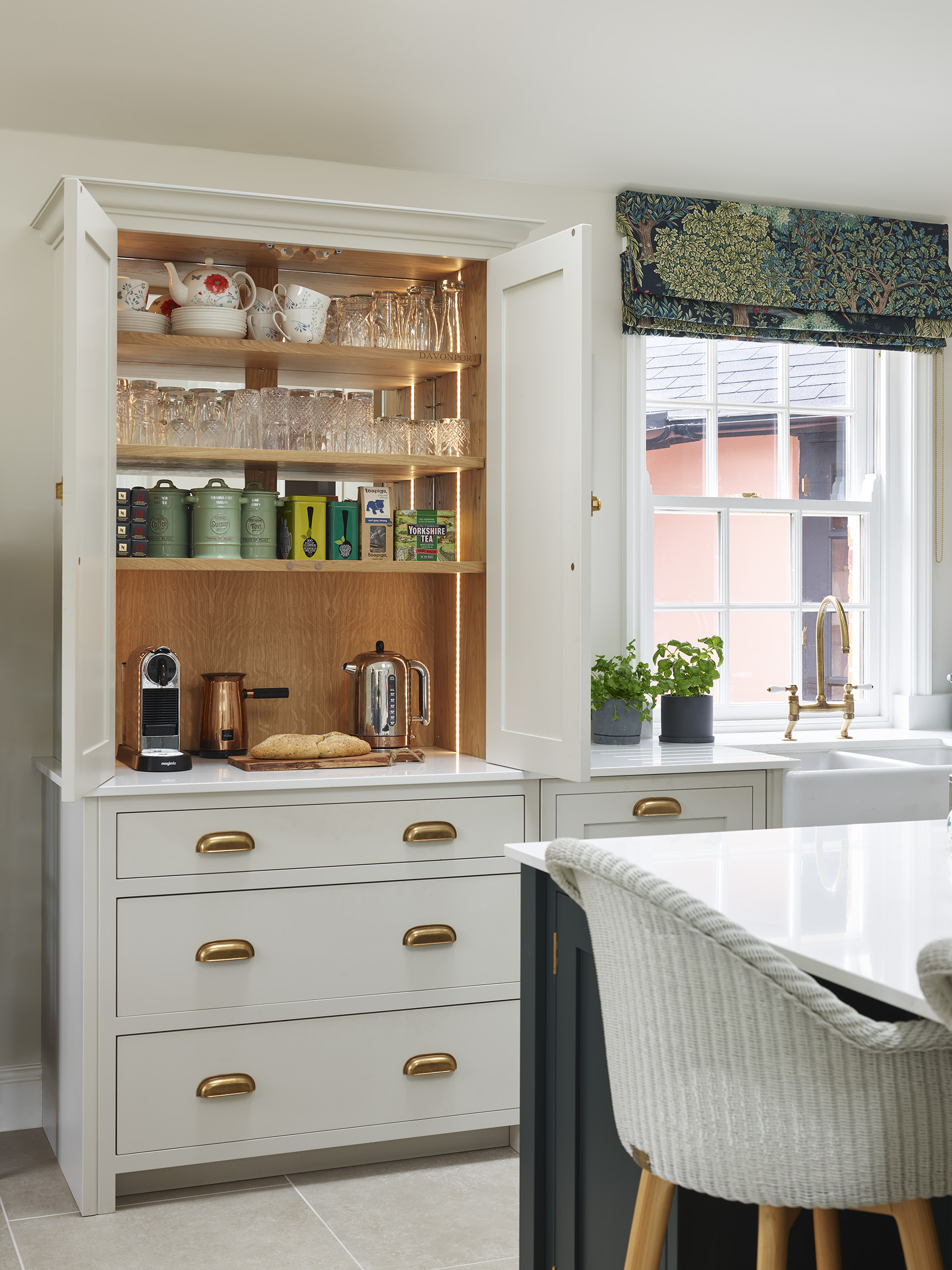 An off-white traditional kitchen with a breakfast nook opened up within a larder unit