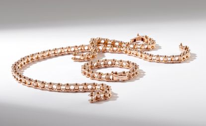 Gold bicycle chain jewellery by Nadine Ghosn on a white background