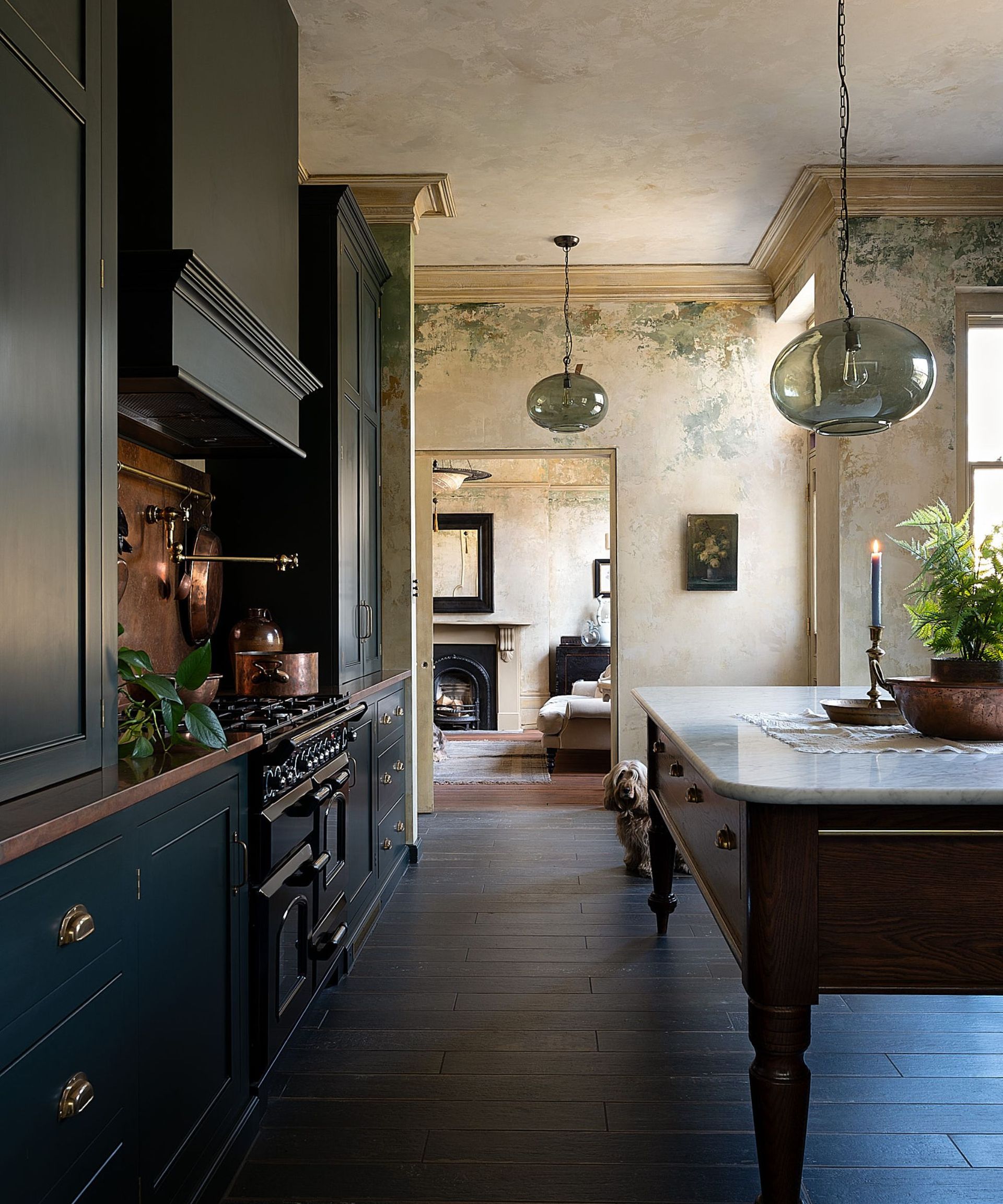 deVOL kitchen with dark green cabinets, copper countertops, a freestanding island, and large glass pendant lights