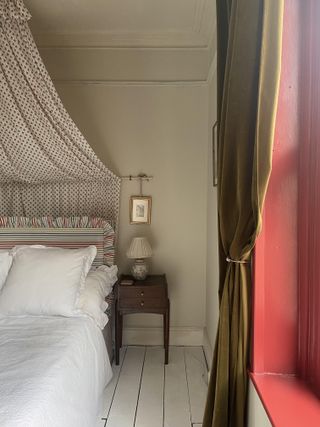 green bedroom with a canopy above the bed