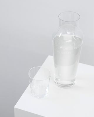 A tall carafe filled with water and a glass.