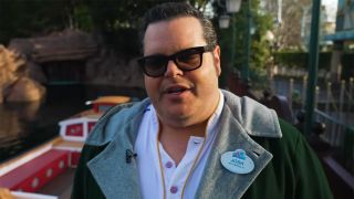 A shot of Josh Gad in a Disneyland cast member uniform standing by the Canal Boats and talking to the camera.