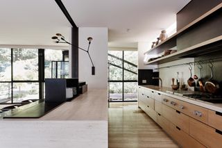 bridging boyd by jolson, a modernist house refreshed with white walls, black framing and details and a overgrown leafy garden seen through large glazing