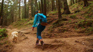 Female hiker exploring forest with dog