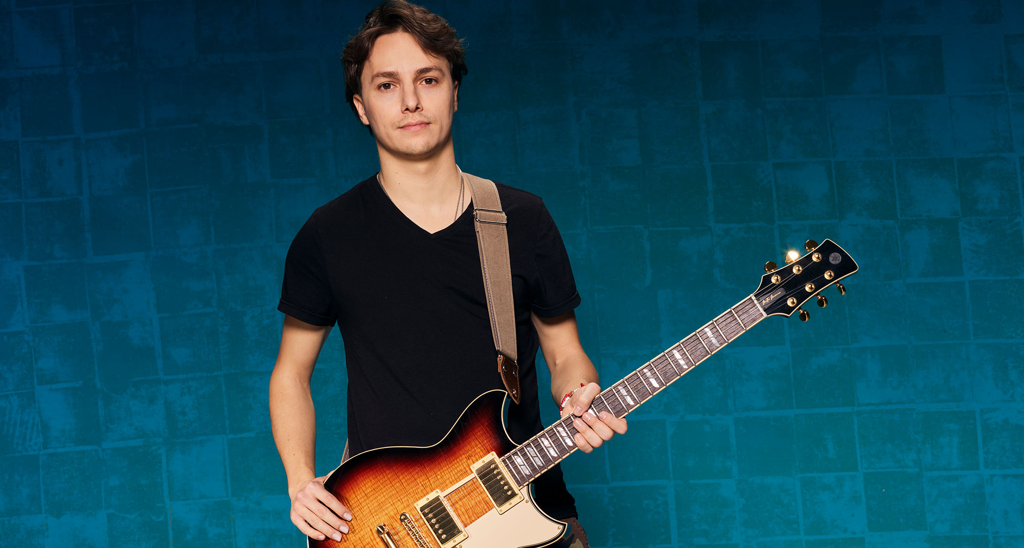 A studio portrait of Matteo Mancuso with his Yamaha Revstar