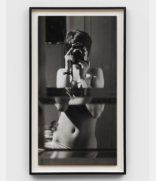 Framed photograph of nude woman photographing own reflection