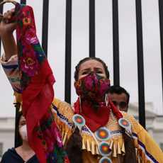 A demonstrator holds up her fist in front of the White House during a climate march in honor of Indigenous Peoples’ Day at on October 11, 2021 in Washington, DC. Activists organized the march to the White House to demand that U.S. President Joe Biden stop approving fossil fuel projects and declare a climate emergency, ahead of the United Nations climate summit in November.