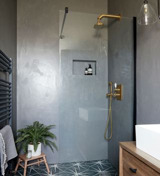 bathroom with printed tiled flooring and shower on wall