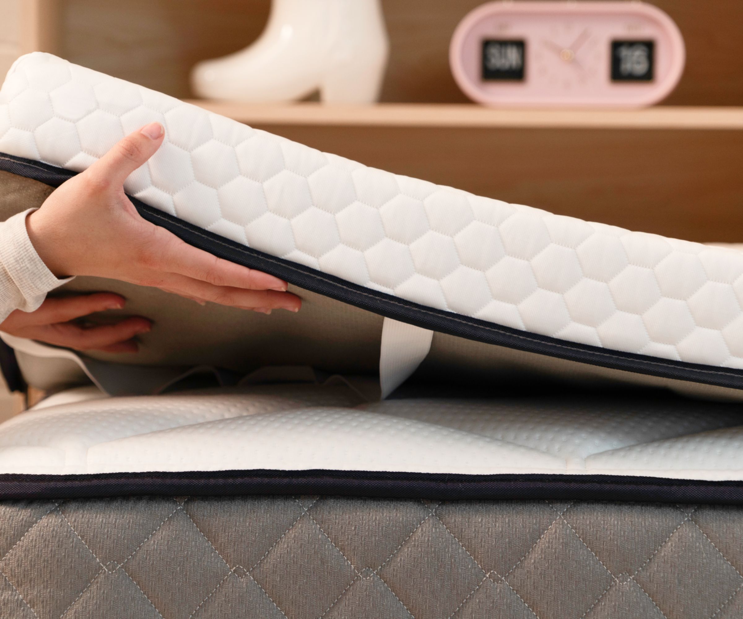 Mattress topper being laid on a bed