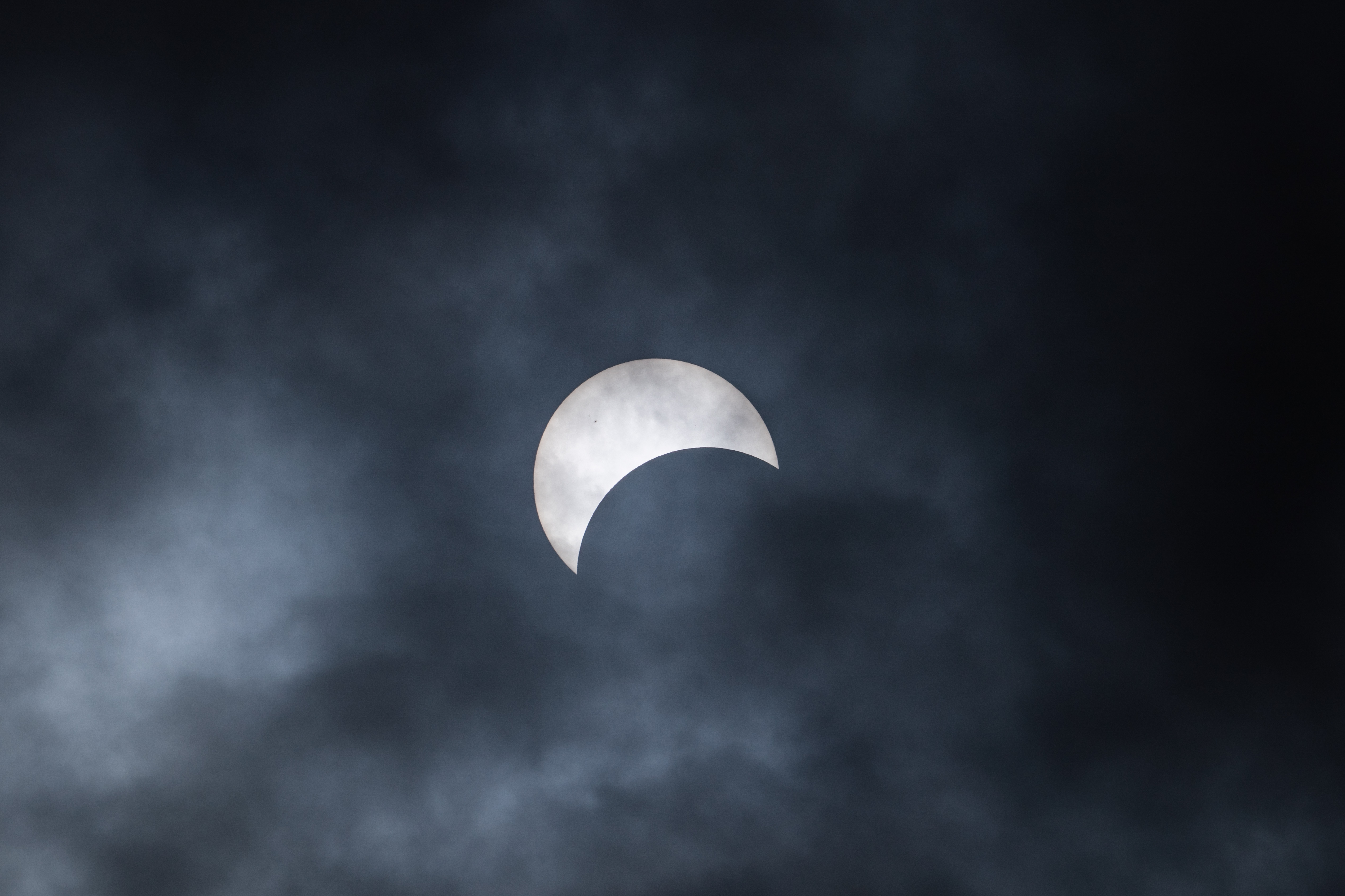 Un'eclissi solare parziale è vista attraverso le nuvole l'8 aprile 2024 alle Cascate del Niagara, New York
