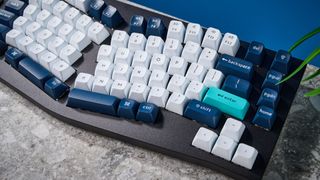 A black Keychron Q14 Max Alice keyboard with white, blue and teal keycaps