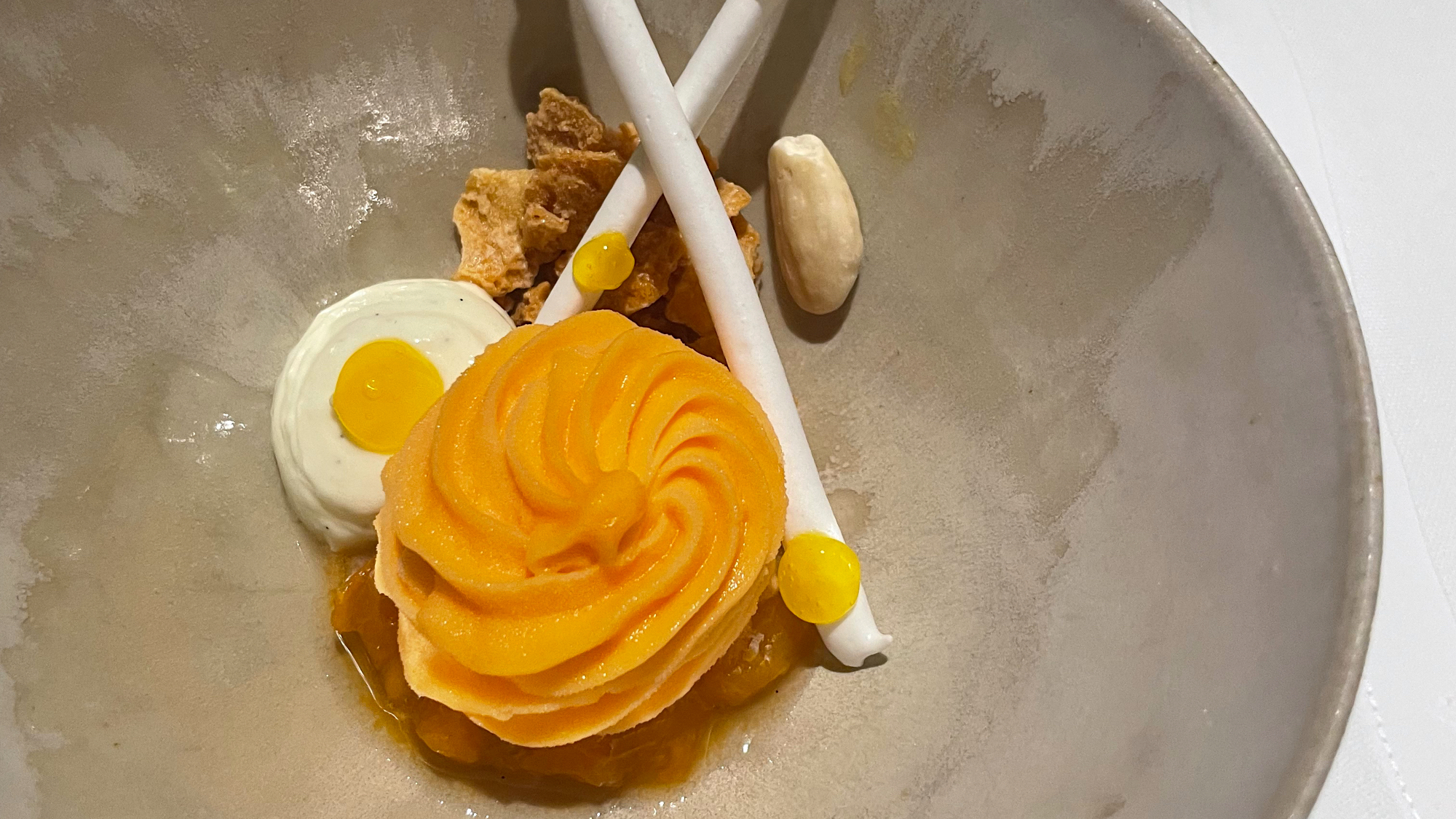 Apricot sorbet, vanilla cream, meringue sticks on a dish at Sensum, Ghent, Belgium