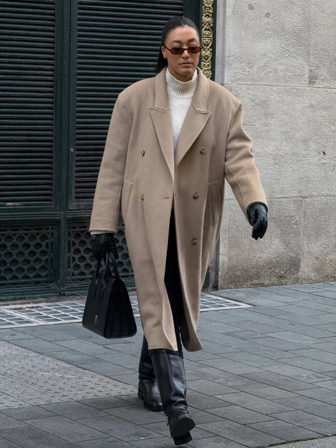 Influencer Tegan Frances wearing an anti-trend outfit of tailored wool coat, leggings and knee-high boots.