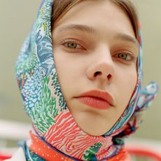Close up portrait of wearing colorful scarf covering her hair and a tinted spf lip balm