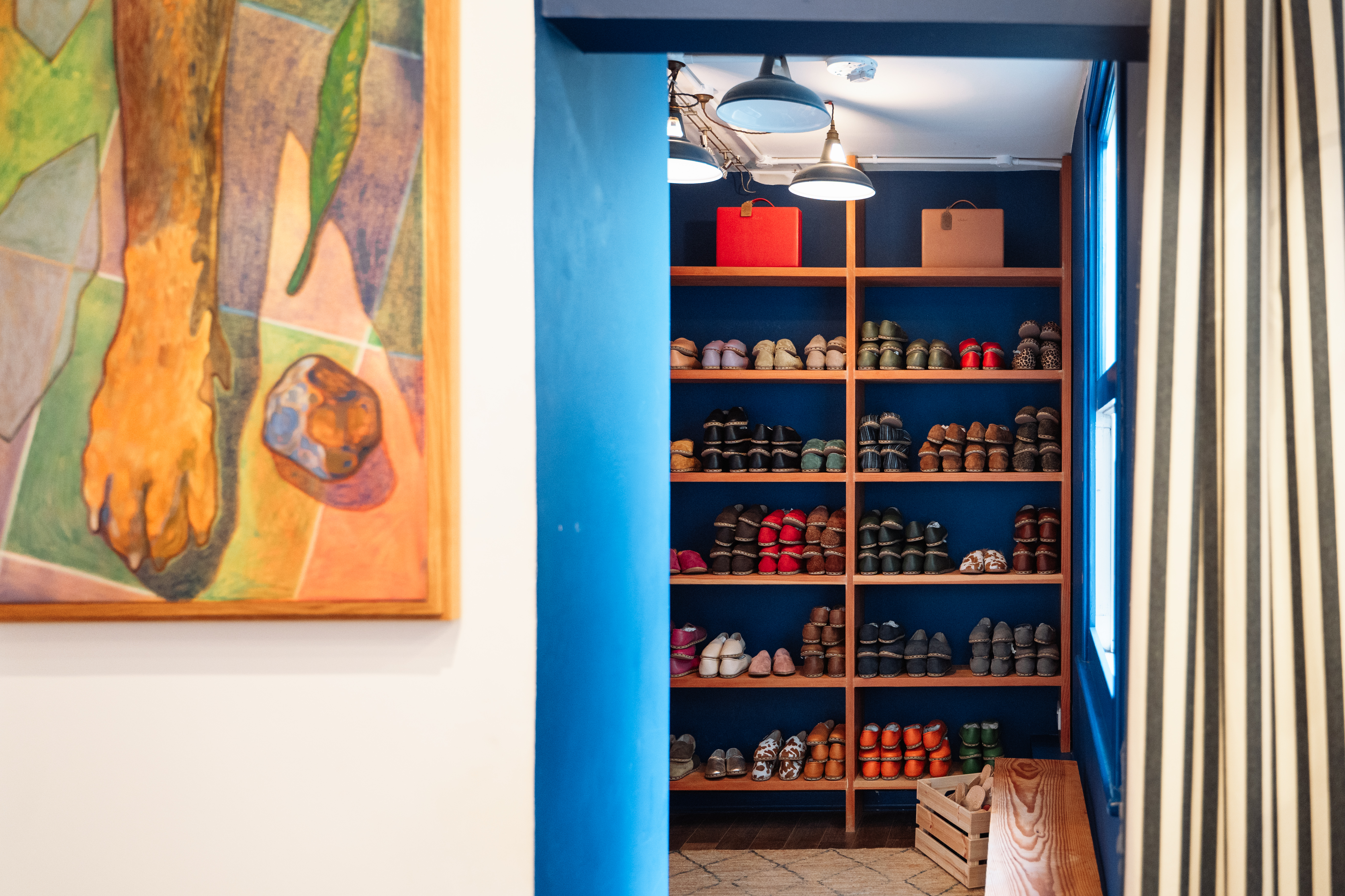 Colourful shoes on shelves in Sabah store, and artwork on wall