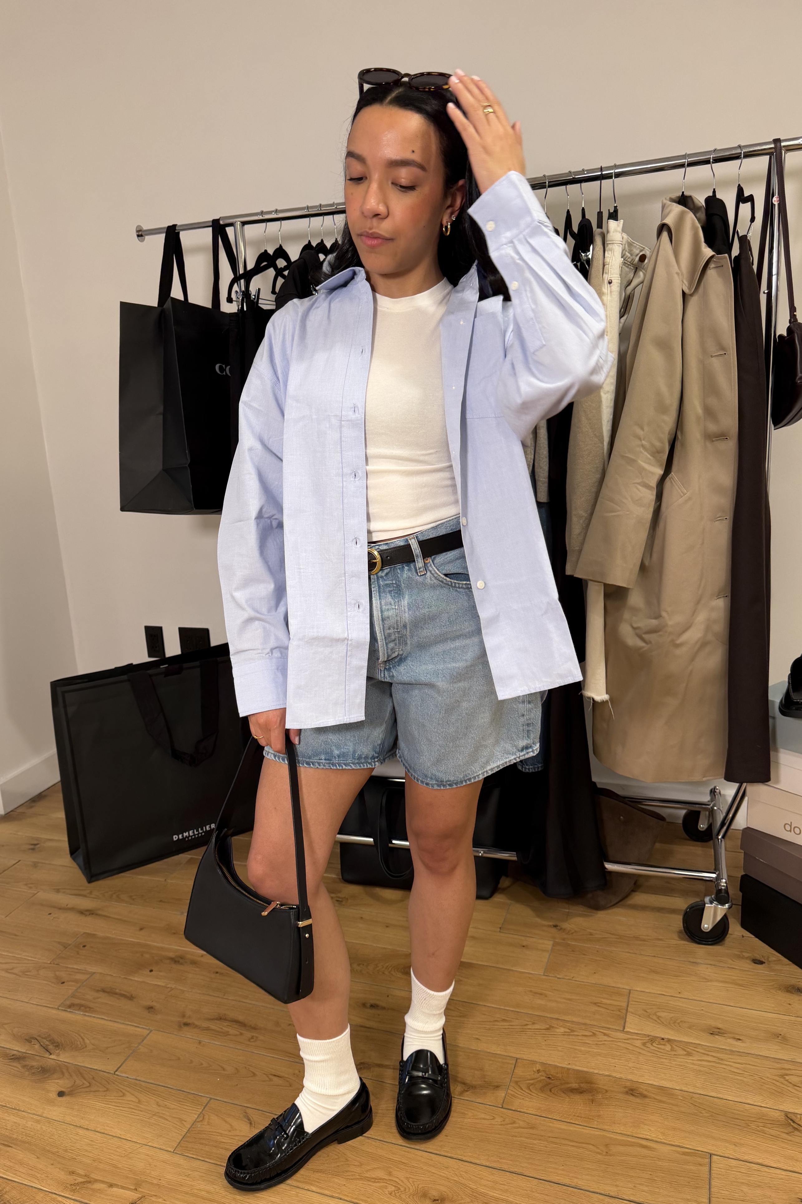 Lauren Tappan wearing a button-down, a tee, bermuda shorts, loafers and socks, and a handbag