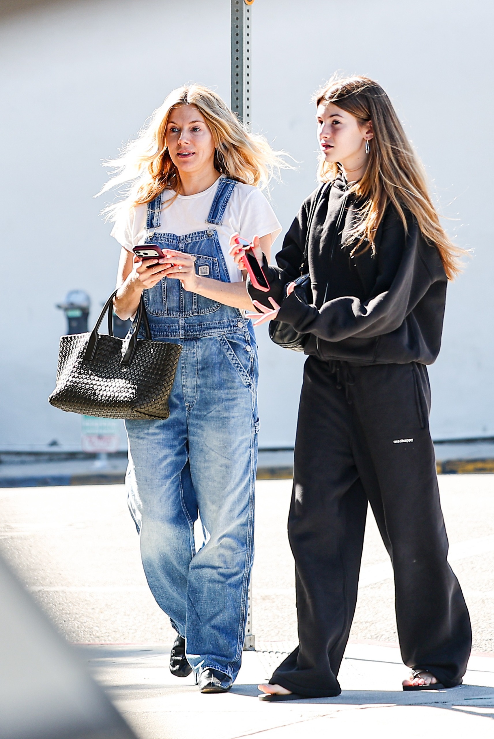 Sienna Miller wore a white T-shirt with denim overalls and high-vamp flats in London