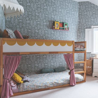 A shared children's bedroom with a scalloped bunk bed and Morris & Co. wallpaper on the walls