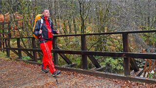Man wearing Haglöfs LIM ZT Trek GTX PRO Jacket crossing a bridge