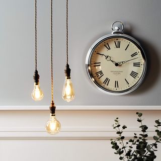 grey wall with wall clock and light bulb