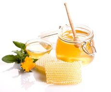 Jar Of Honey Next To Honeycombs