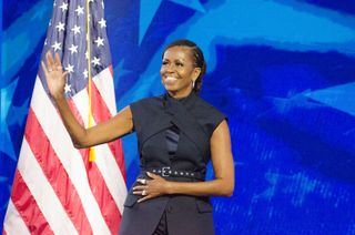 michelle obama speaks at the 2024 democratic national convention in a futuristic black Monse suit