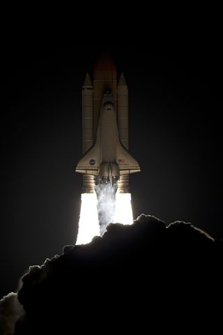 Space shuttle Discovery launches into the pre-dawn sky to the International Space Station.