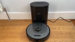 The Proscenic M8 Pro on its charging base on a hard floor