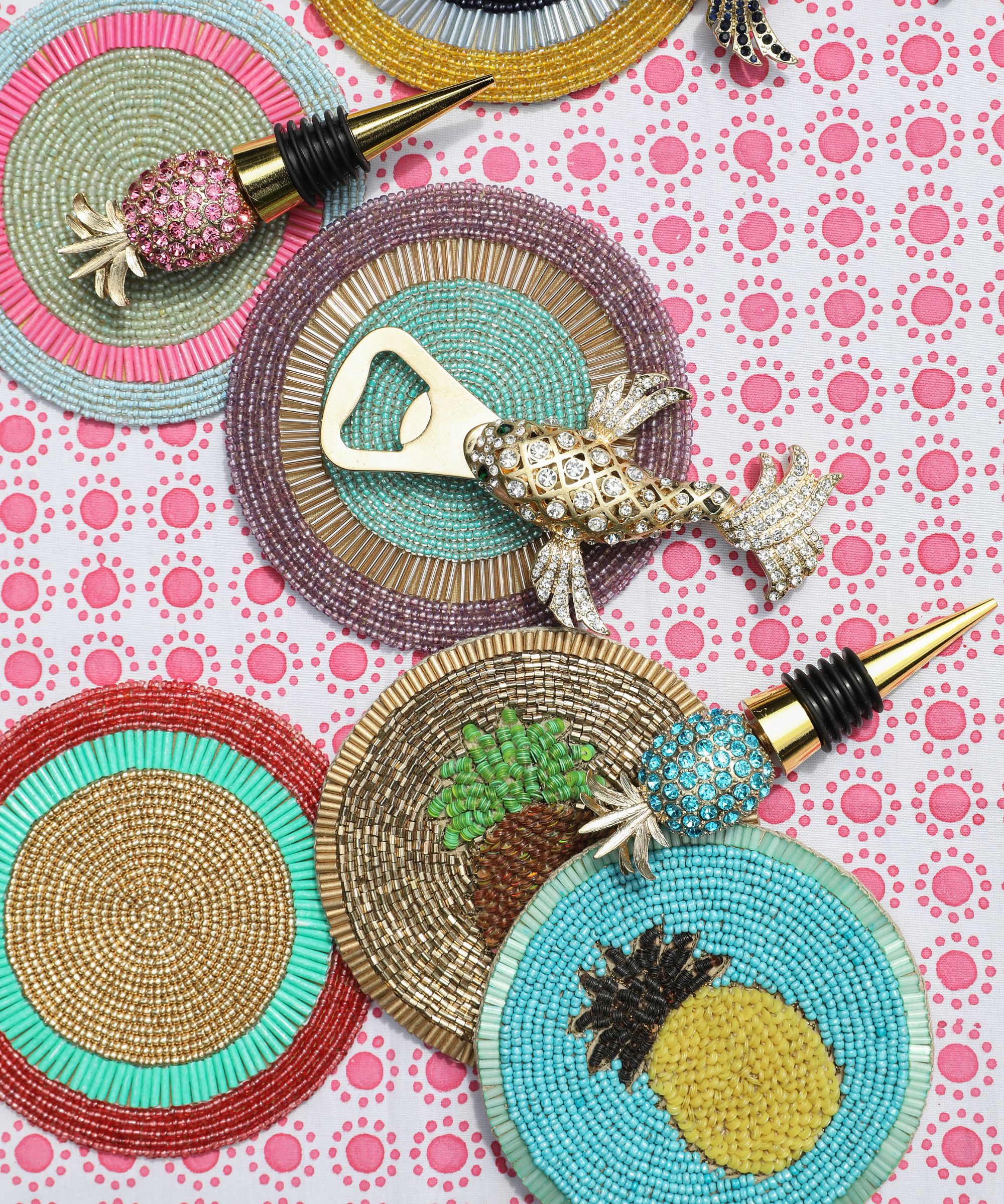 Colorful beaded coasters and bottle openers on a pink and white tablecloth