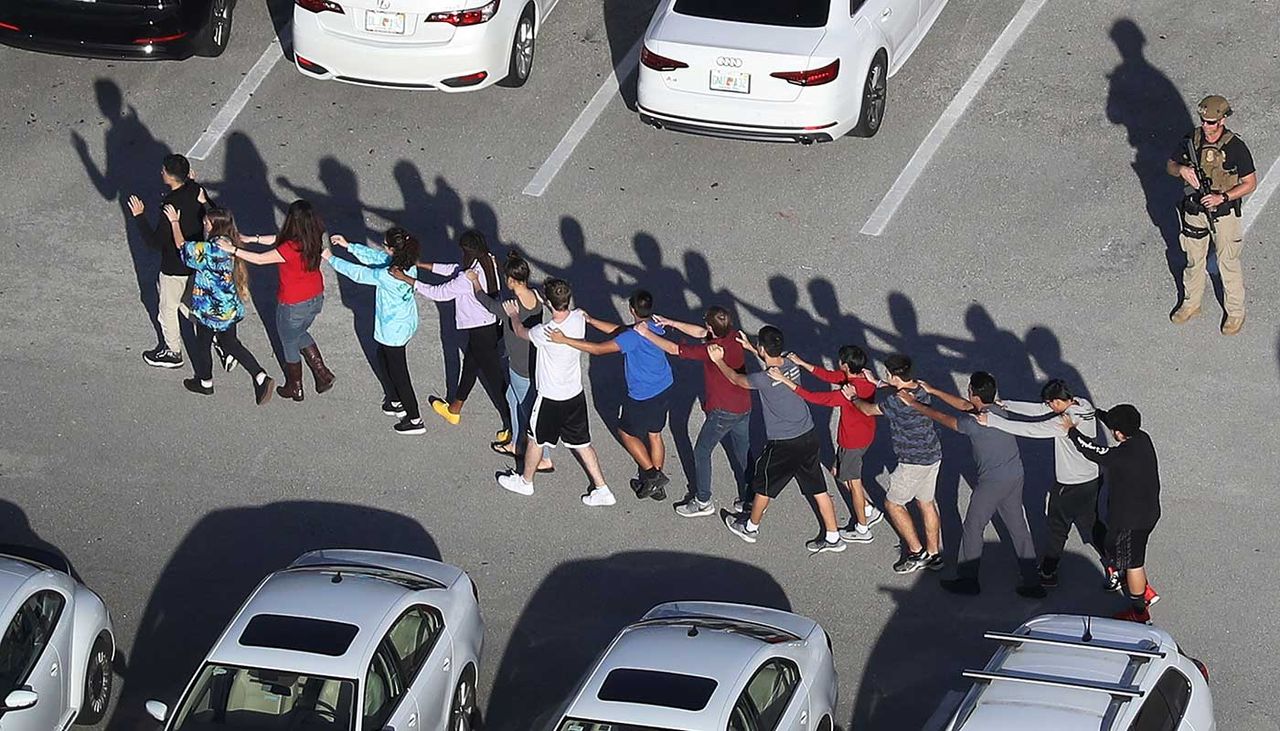 Students and staff are escorted from the school following the shooting